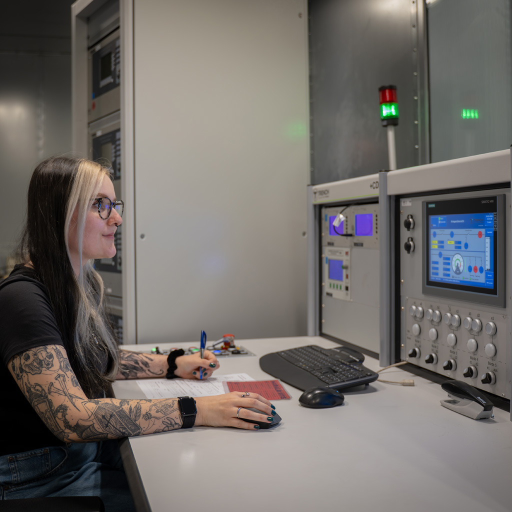 Victoria Bold monitoring testing equipment and control screens at Trench Group's high-voltage test facility in Bamberg.